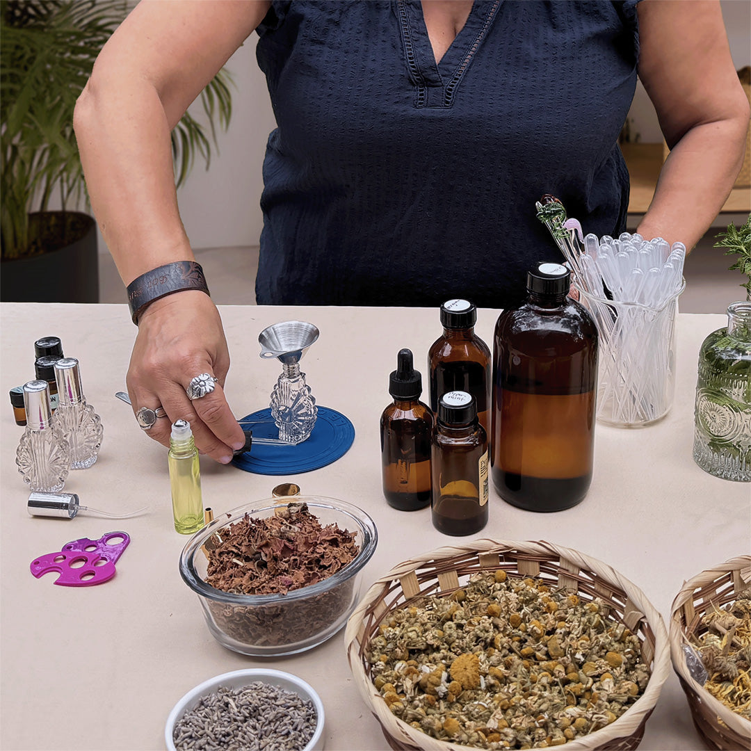 A person mixing essential oils with various ingredients in front of them