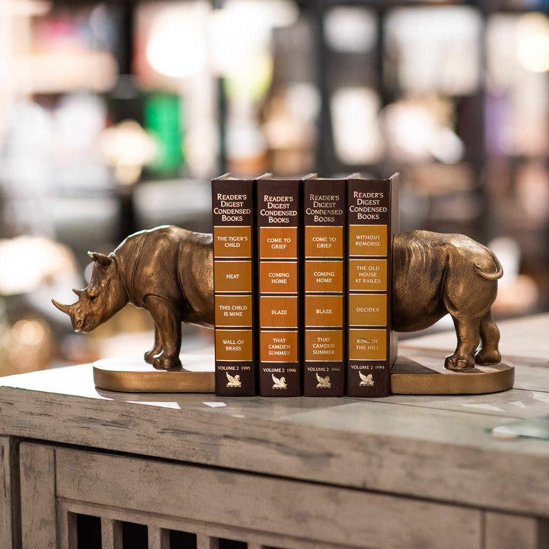 A stack of four vintage books with rhinoceros bookends