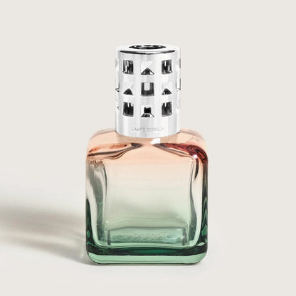 Elegant perfume bottle with metallic cap and gradient glass design.