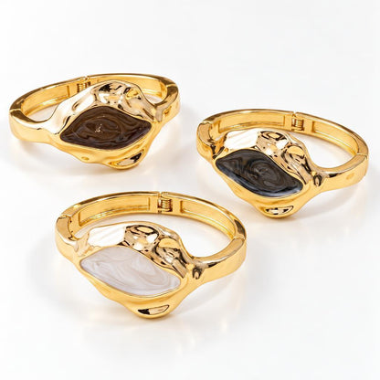 Three gold bracelets with multicolored stone designs.