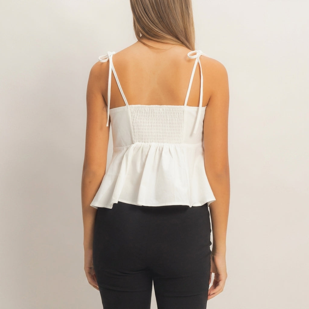 Woman in a white top and black pants, seen from behind.