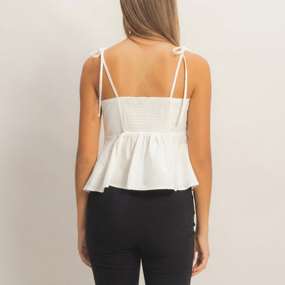Woman in a white top and black pants, seen from behind.