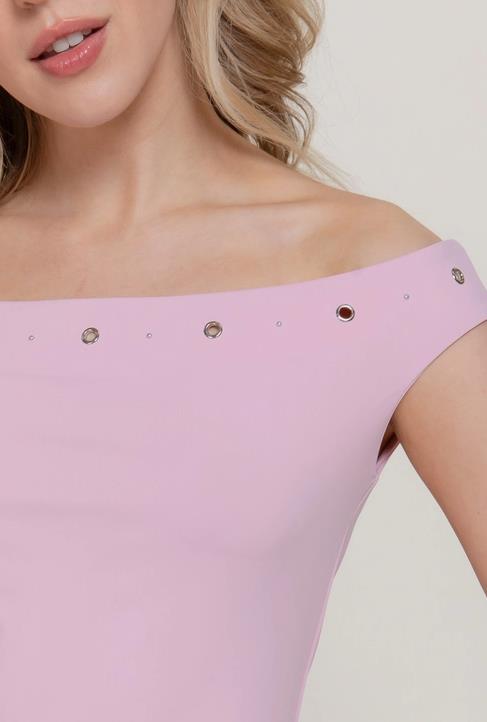 Off-shoulder pink top with decorative accents, worn by a person with wavy blonde hair.