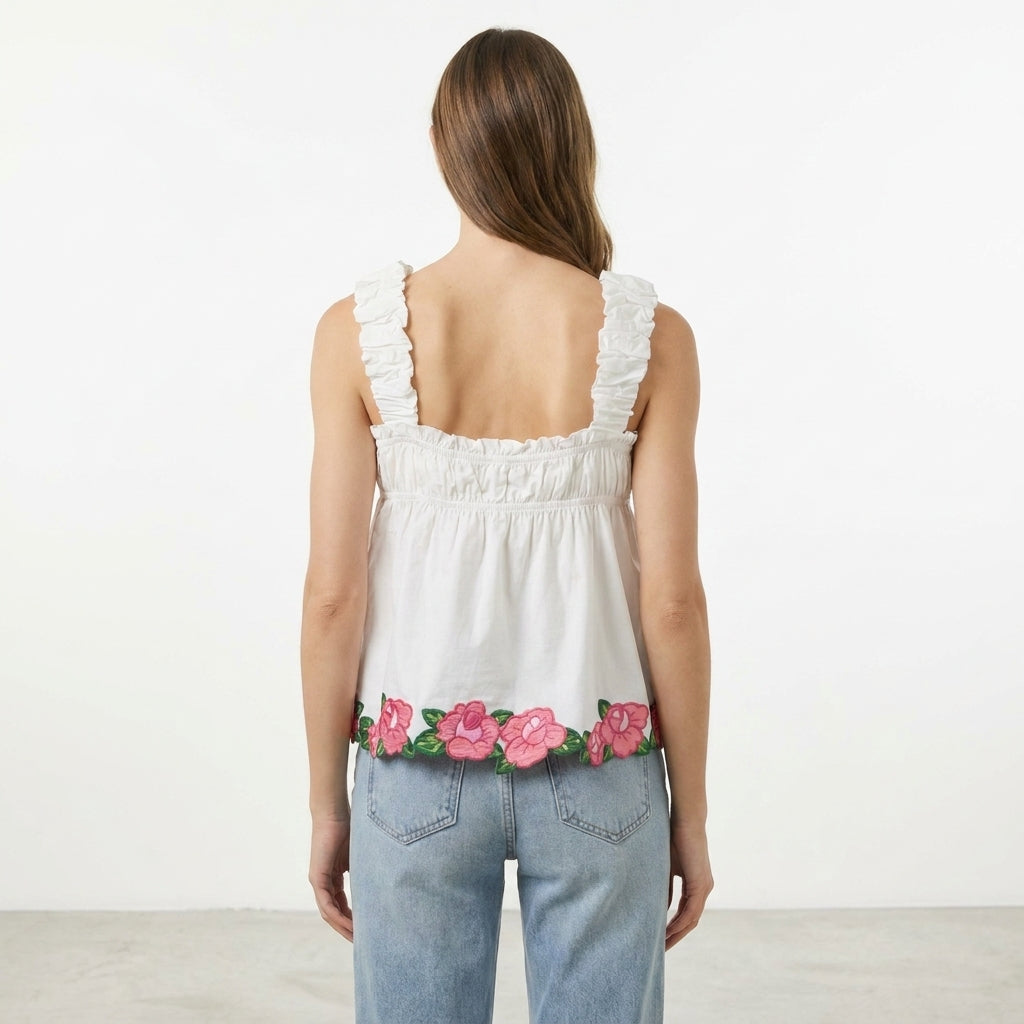 Woman in floral-hem top and jeans, back view.