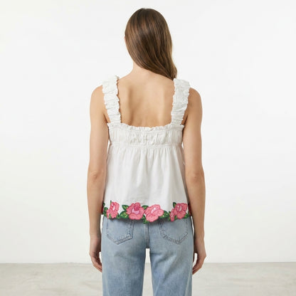 Woman in floral-hem top and jeans, back view.