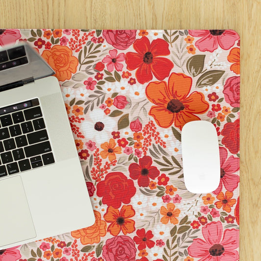 Laptop and mouse on a floral desk mat.
