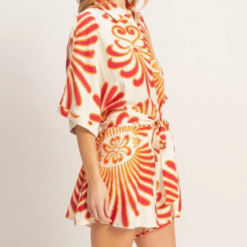 Woman in a floral, short-sleeve belted dress.