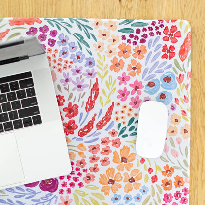 Laptop and mouse on a colorful floral design mat.
