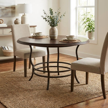 Cozy dining setup with round table, two chairs, and potted plants.