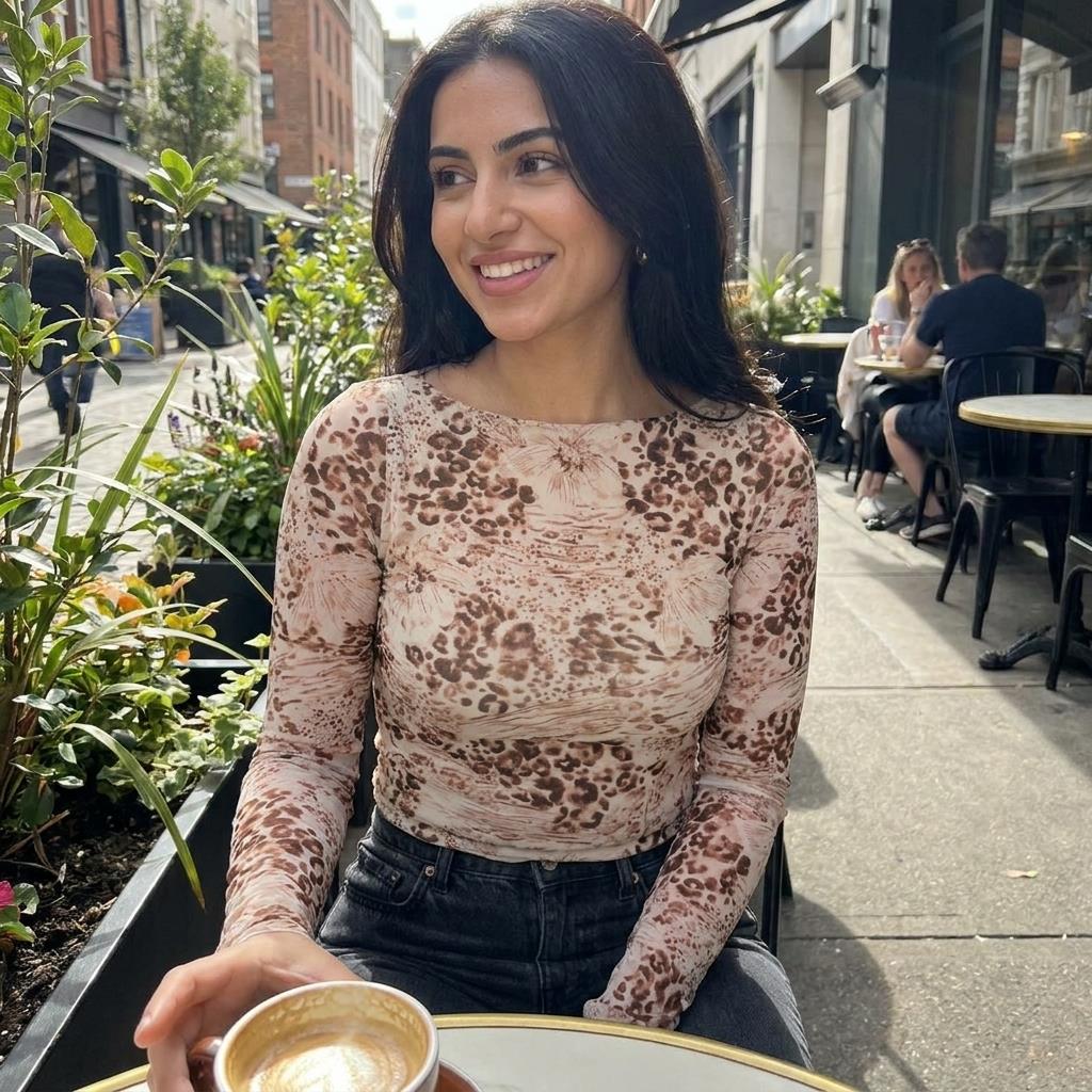Smiling woman enjoys coffee at an outdoor cafe.