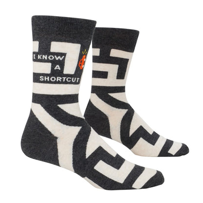 Socks with "I KNOW A SHORTCUT" graphic in black and white.