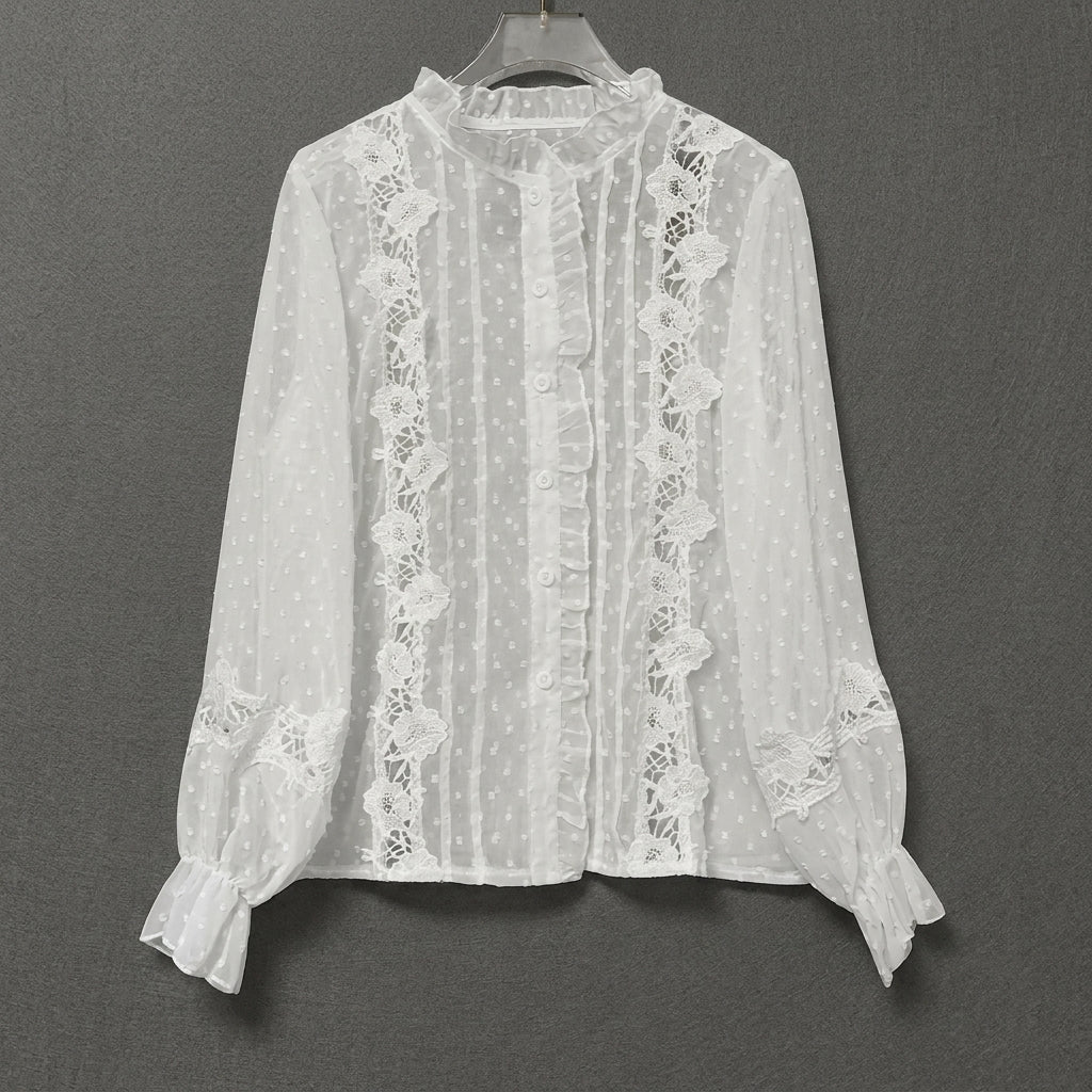 White lace blouse with ruffles and floral details on a hanger.