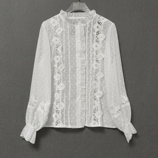 White lace blouse with ruffles and floral details on a hanger.