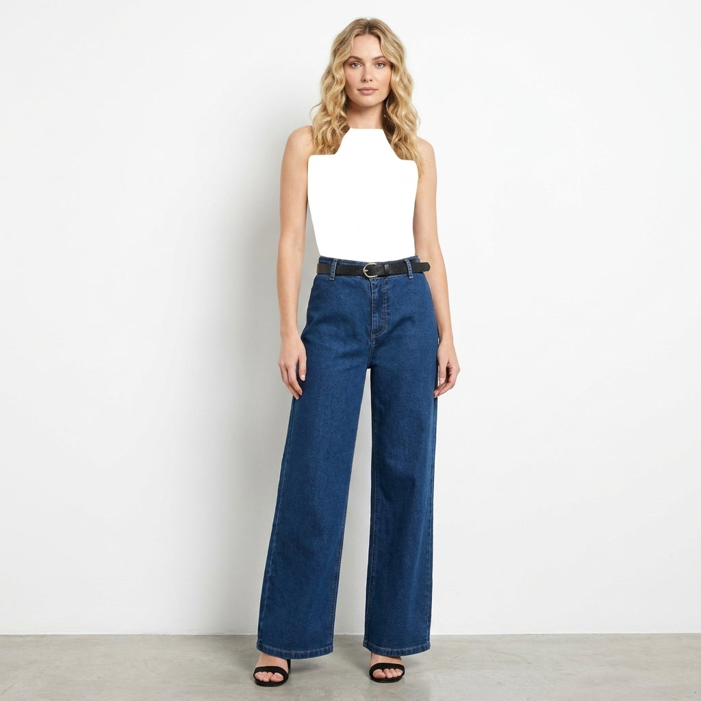Woman in white top and wide-leg jeans against a plain background.