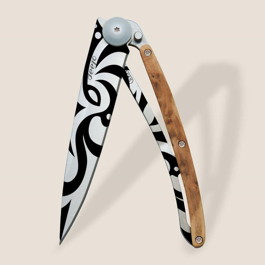Artistic knife with black and white blade, wooden handle.
