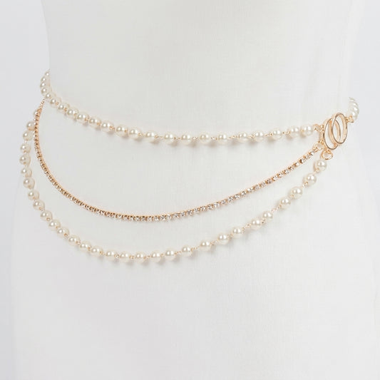 Elegant triple-layer pearl waist chain on a white mannequin.