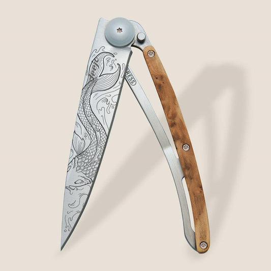 Engraved folding knife with wooden handle, featuring ornate fish design.