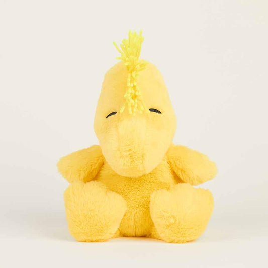 Yellow plush bird with tufted hair, eyes closed, against a plain background.