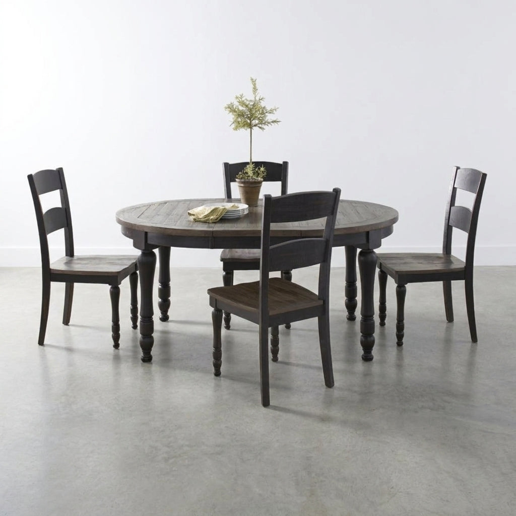 Round table with four dark chairs and small plant centerpiece.
