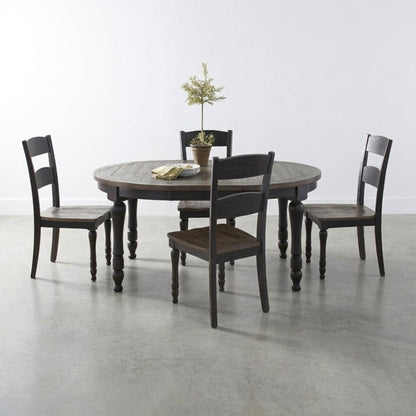 Round table with four dark chairs and small plant centerpiece.