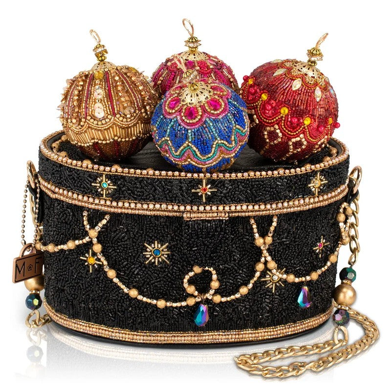 A black beaded purse adorned with colorful, ornate decorations on top.