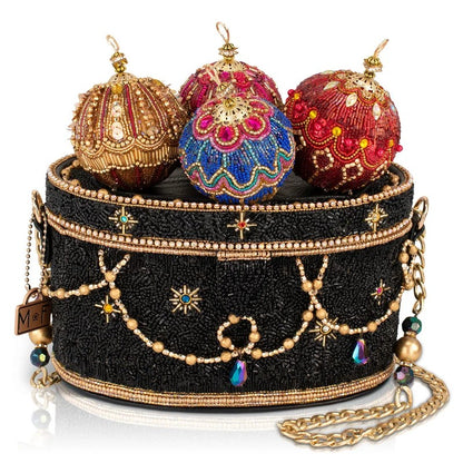 A black beaded purse adorned with colorful, ornate decorations on top.