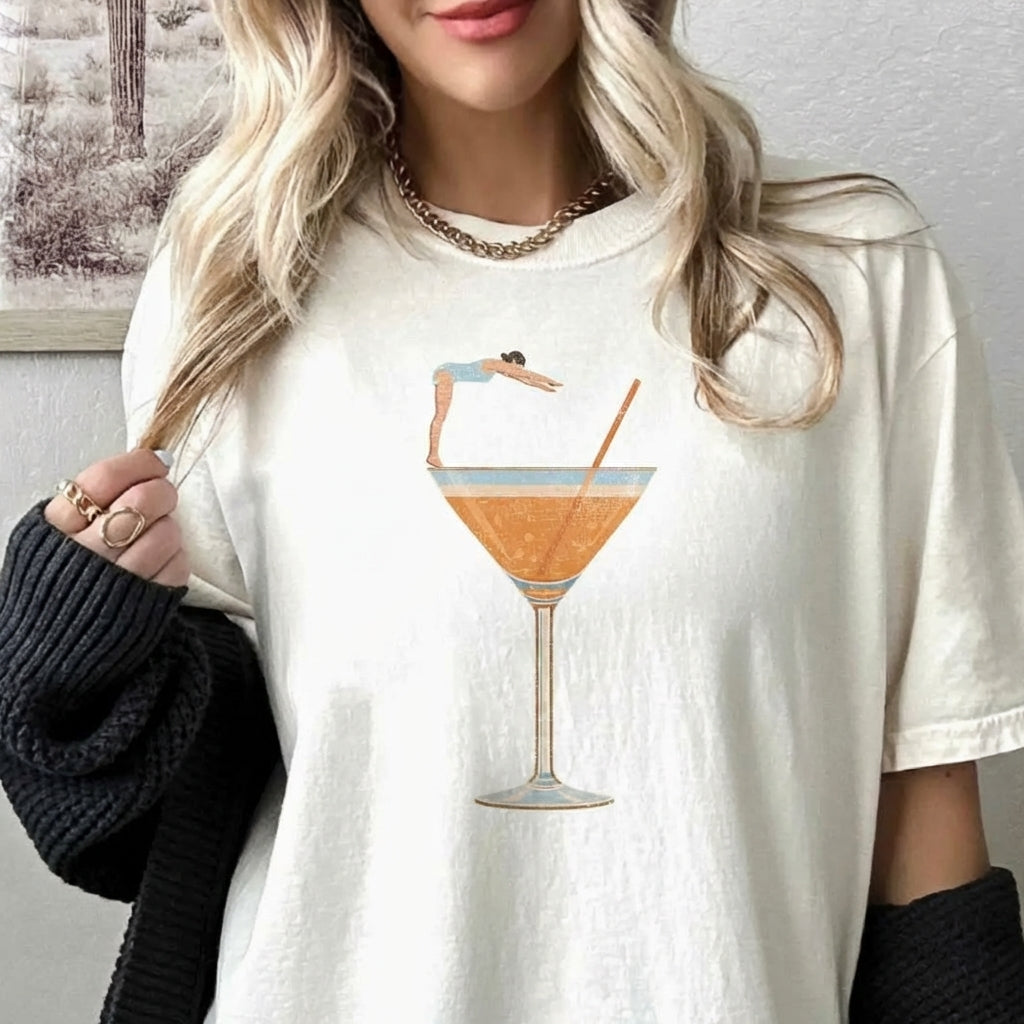Woman in tee with a diving graphic, cozy sweater, and casual style.