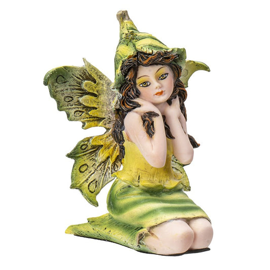 Fairy figurine with green wings and hat, sitting with hands on cheeks.