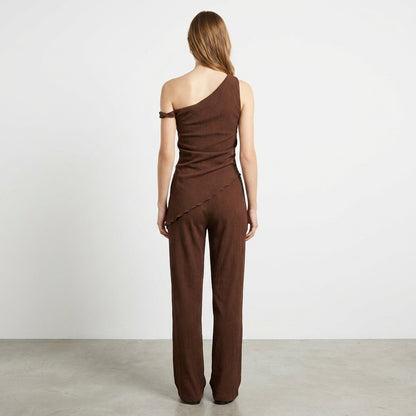 Woman in a one-shoulder brown outfit, viewed from the back.