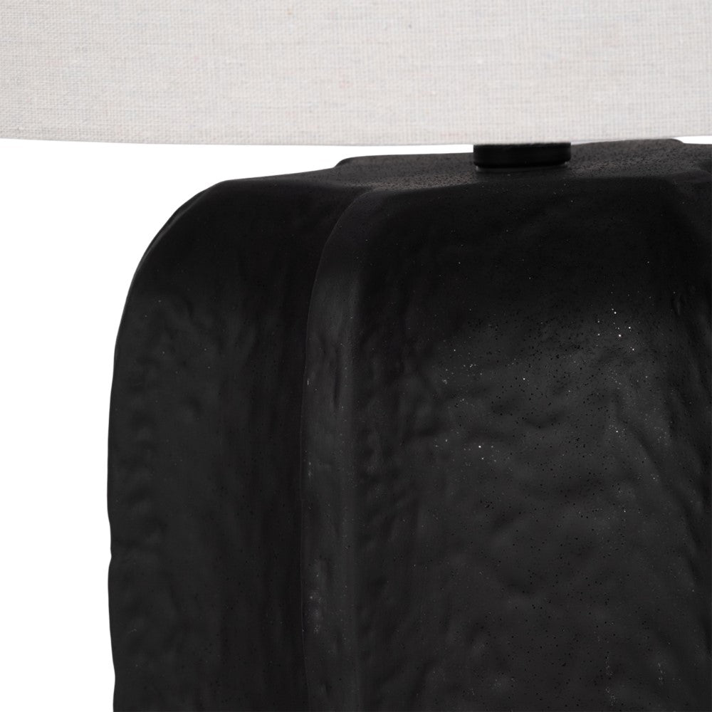 Black textured lamp base with a white fabric shade above.