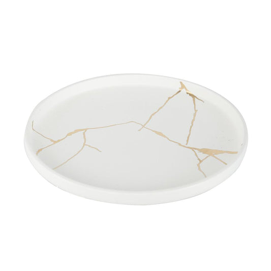 White plate with a gold crack-like pattern, minimalist design.