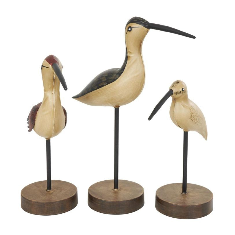 Three wooden bird sculptures on round bases.