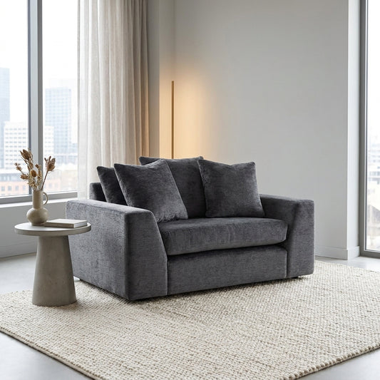 Gray loveseat with three plush pillows.
