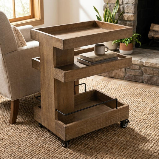 A rustic wooden rolling side table with three tiered trays beside a cozy armchair.