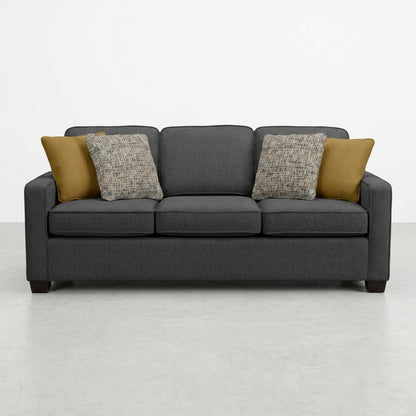 Dark gray sofa with four cushions on a light floor.