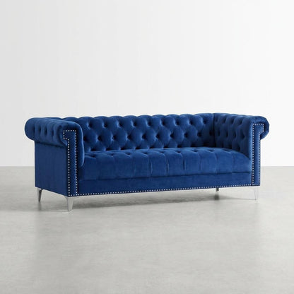 Luxurious blue velvet sofa with tufted cushions and studded accents.