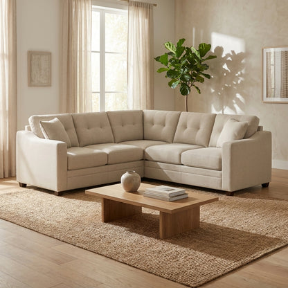 Beige tufted sectional sofa on a gray floor.
