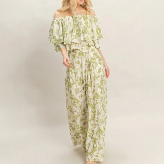 Woman in a floral off-shoulder outfit against a plain background.