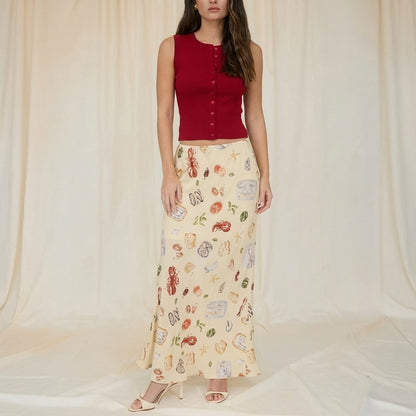 Person in a printed skirt on a terrace by the sea.