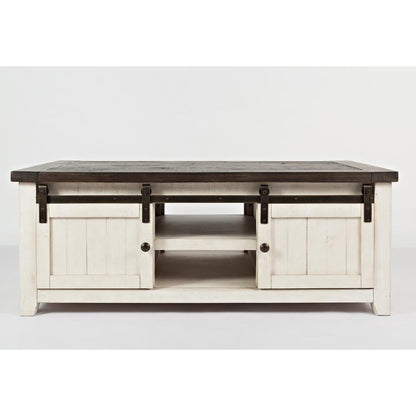 Rustic white coffee table with sliding barn doors and dark top.