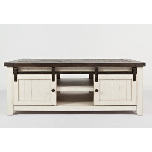Rustic white coffee table with sliding barn doors and dark top.