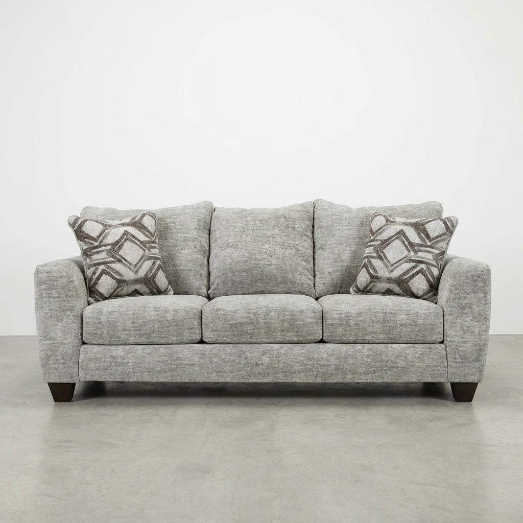 Gray sofa with patterned pillows on a plain background.