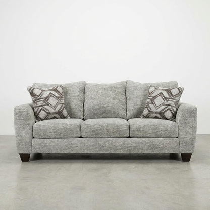 Gray sofa with patterned pillows on a plain background.