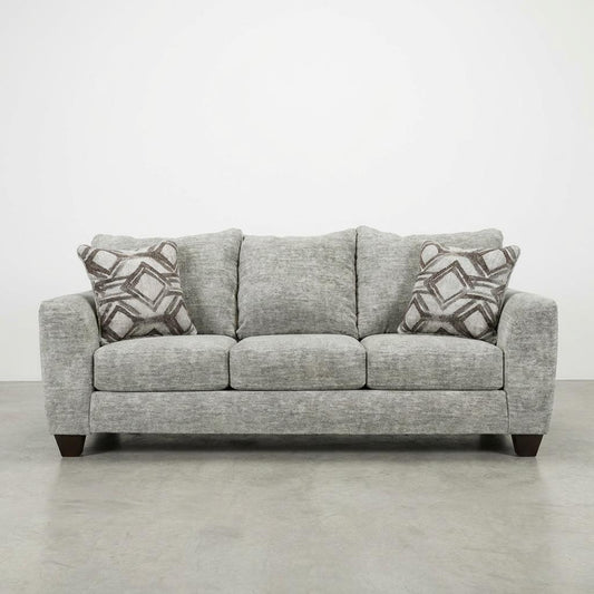 Gray sofa with patterned pillows on a plain background.