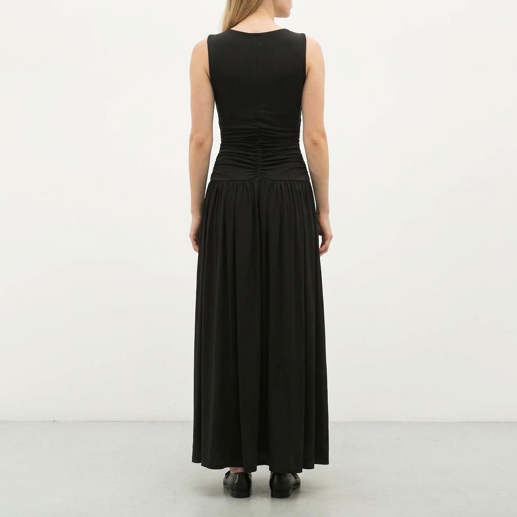 Woman in a long black dress, seen from the back.