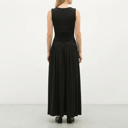 Woman in a long black dress, seen from the back.