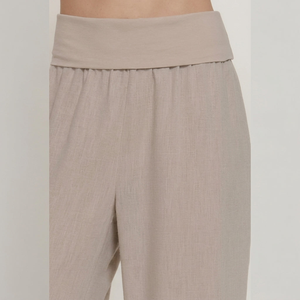 Beige high-waisted wide-leg pants on a model.