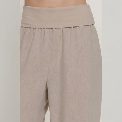 Beige high-waisted wide-leg pants on a model.