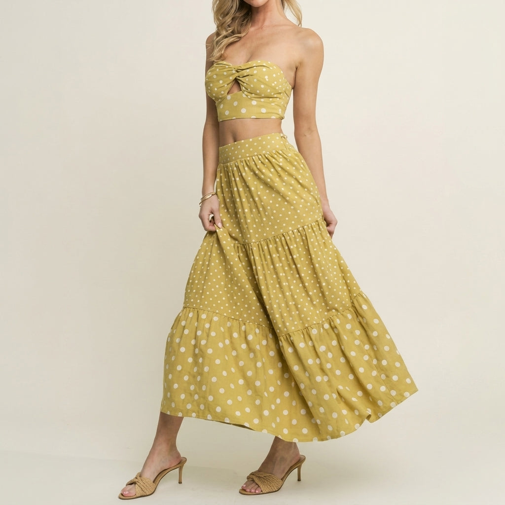 Model in yellow polka dot skirt and top, wearing heels.