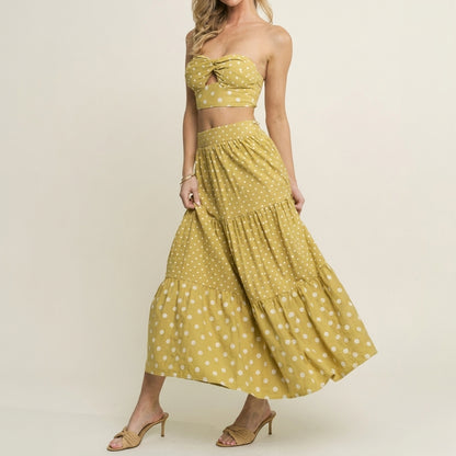 Model in yellow polka dot skirt and top, wearing heels.